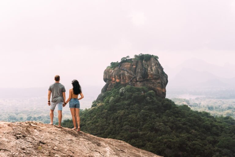 A couple in love on a rock admires the beautiful views. A couple in love travels